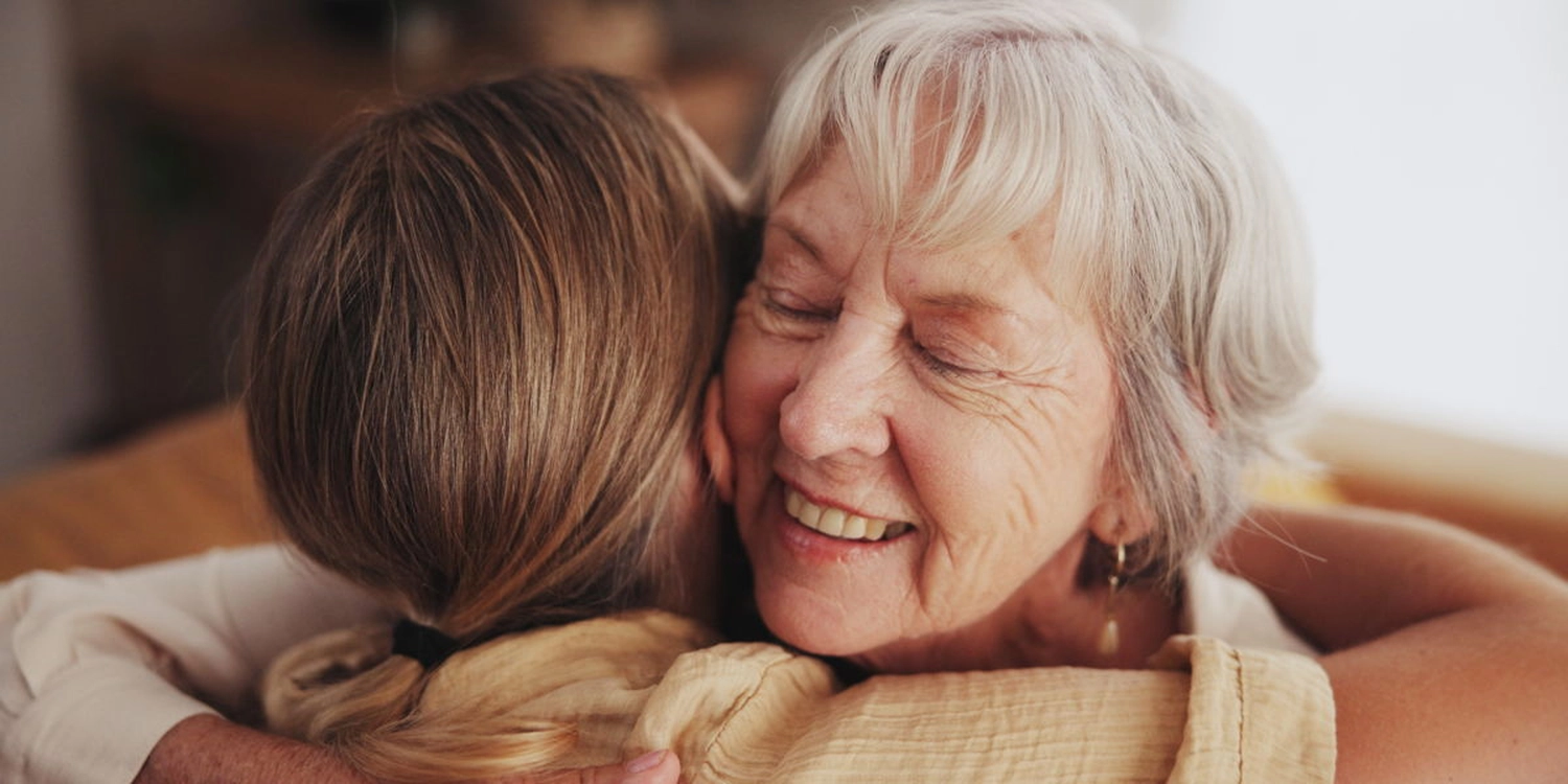 Eine alte Frau umarmet eine Altenpflegerin des Pflegedienst Papillon aus Windeck.
