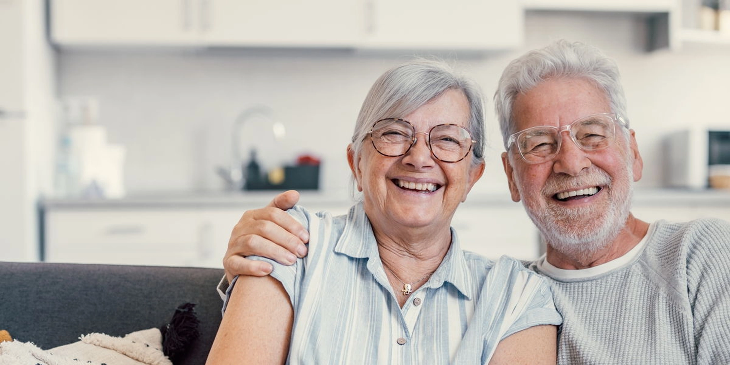 Ein glückliches älteres Ehepaar freut sich über umfassende Pflegeleistungen von Papillon.