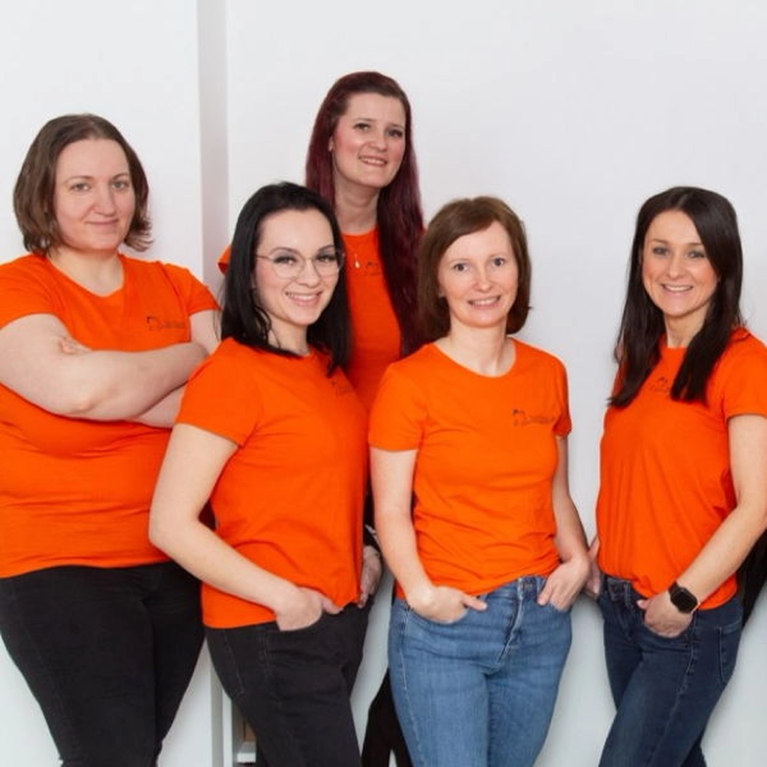 Grupppenfoto von orange gekleideten Frauen des Pflegedienst Papillon.