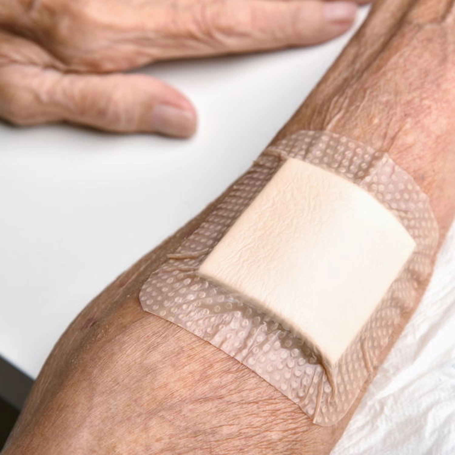 Ein Pflaster auf dem Arm einer älteren Dame.